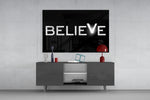 Believe glass wall art catching light to reveal its painted V