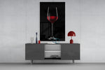 Wine glass wall art catching light to reveal its painted ruby tones