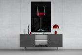 Wine glass wall art catching light to reveal its painted ruby tones