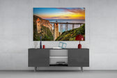 Bixby Creek Bridge glass wall art catching light to reveal its painted sunset tones