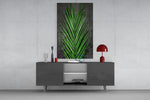 Areca Bunch glass wall art catching light to reveal its painted emerald frond