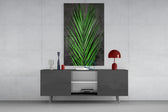 Areca Bunch glass wall art catching light to reveal its painted emerald frond