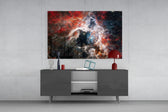 Space glass wall art catching light to reveal its painted nebula tones