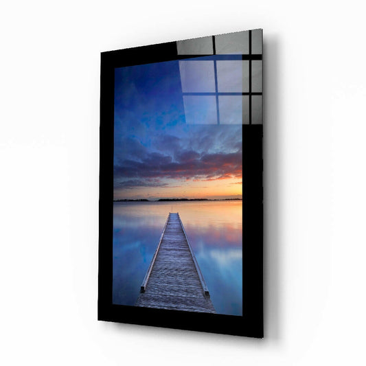 Sunset on the Dock glass wall art displayed above a bed in a bedroom