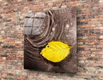 Saffron-leaf on obsidian water cinematic glass wall art in hygge-bedroom