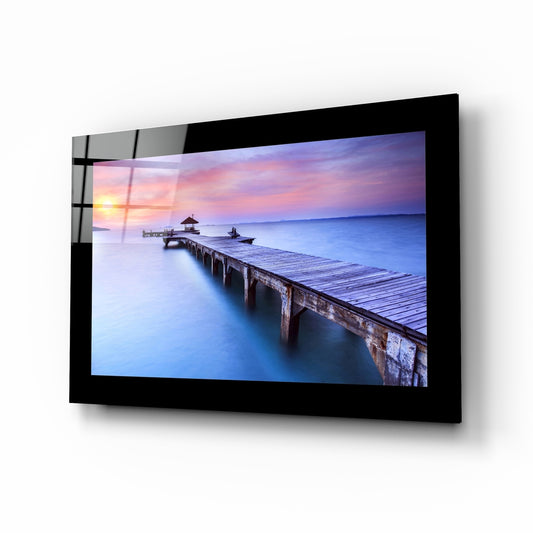 Sunset at the Pier glass wall art displayed above a bed in a bedroom