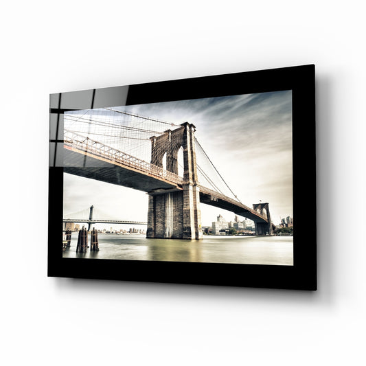 Brooklyn Bridge glass wall art displayed above a sideboard in a study