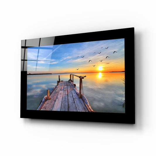 Sunset glass wall art displayed above a bed in a bedroom