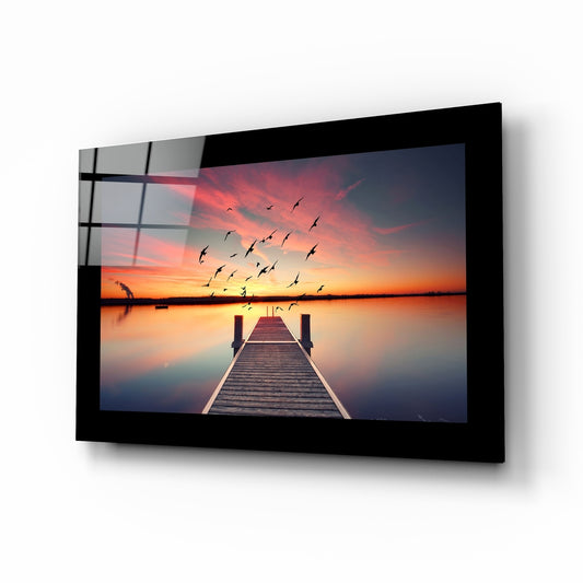 Sunset glass wall art displayed above a bed in a bedroom