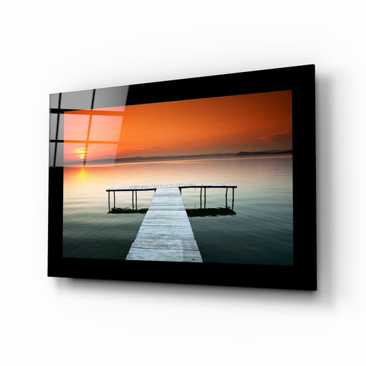 Sunset glass wall art displayed above a bed in a bedroom