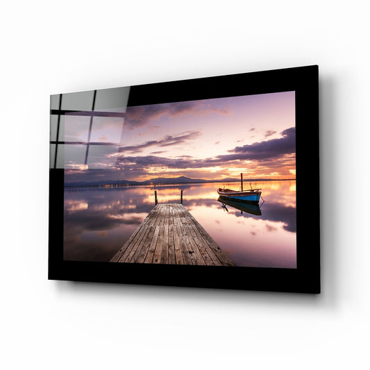 Sunset glass wall art displayed above a bed in a bedroom