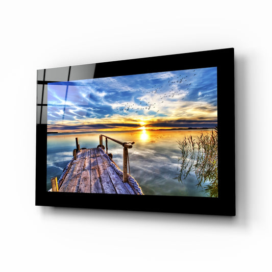 Sunset at Pier glass wall art displayed above a bed in a bedroom